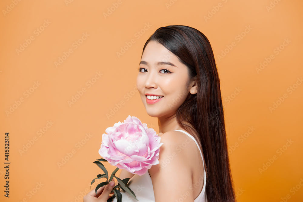 beautiful young woman with pink flower isolated on yellow beautiful young woman with pink flower isolated on yellow