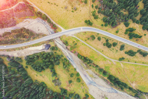 Aerial view of the mountains in autumn. The winding road along the river. Beautiful nature landscape. Bridge over the Prut River near Tatariv village, Carpathian mountains. Ukraine photo