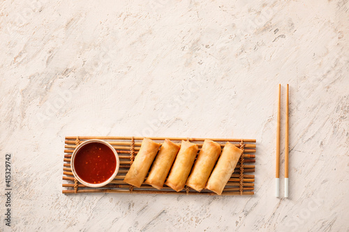 Tableau sur toile Tasty fried spring rolls and sauce on light background