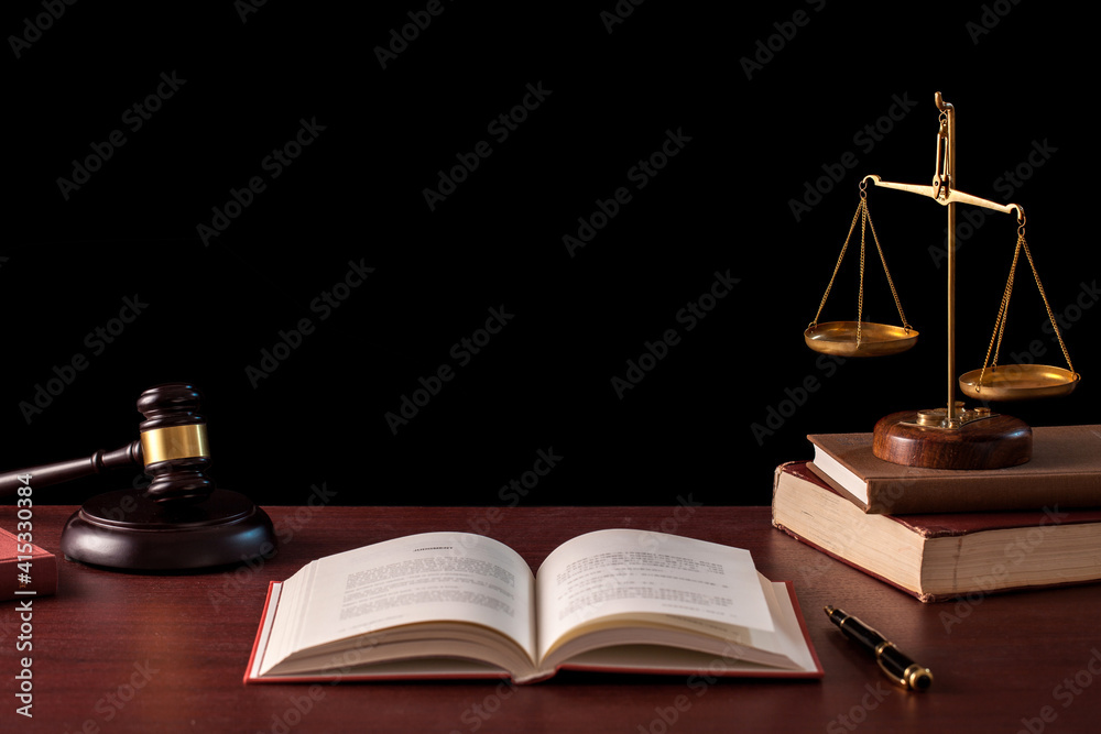 scales of justice, wooden judge gavel with opening law book on table on black background. copy space. scales of justice, wooden judge gavel with opening law book on table on black background. copy space.