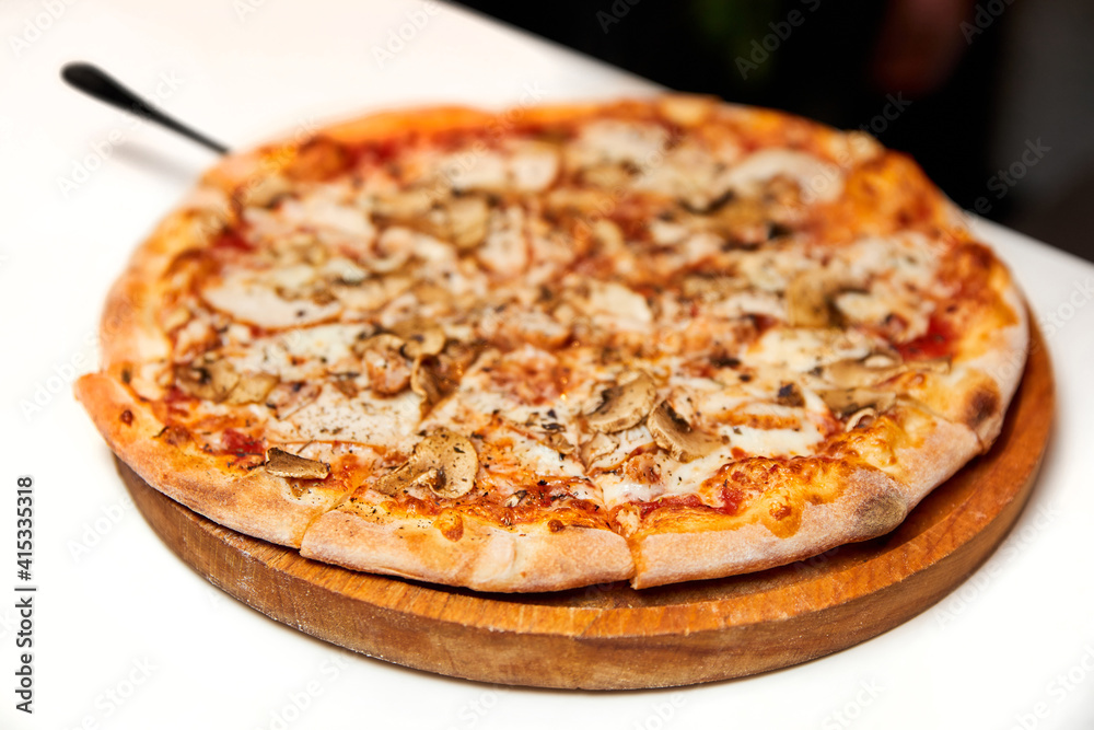 Fresh pizza with bacon, mushrooms and cheese on a light background. Close-up, selective focus Fresh pizza with bacon, mushrooms and cheese on a light background. Close-up, selective focus