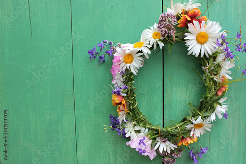 Flower door wreath. Midsummer flower crown on rustic wooden background with copy space. DIY floral wreath. Midsummer night dream decoration
 photo