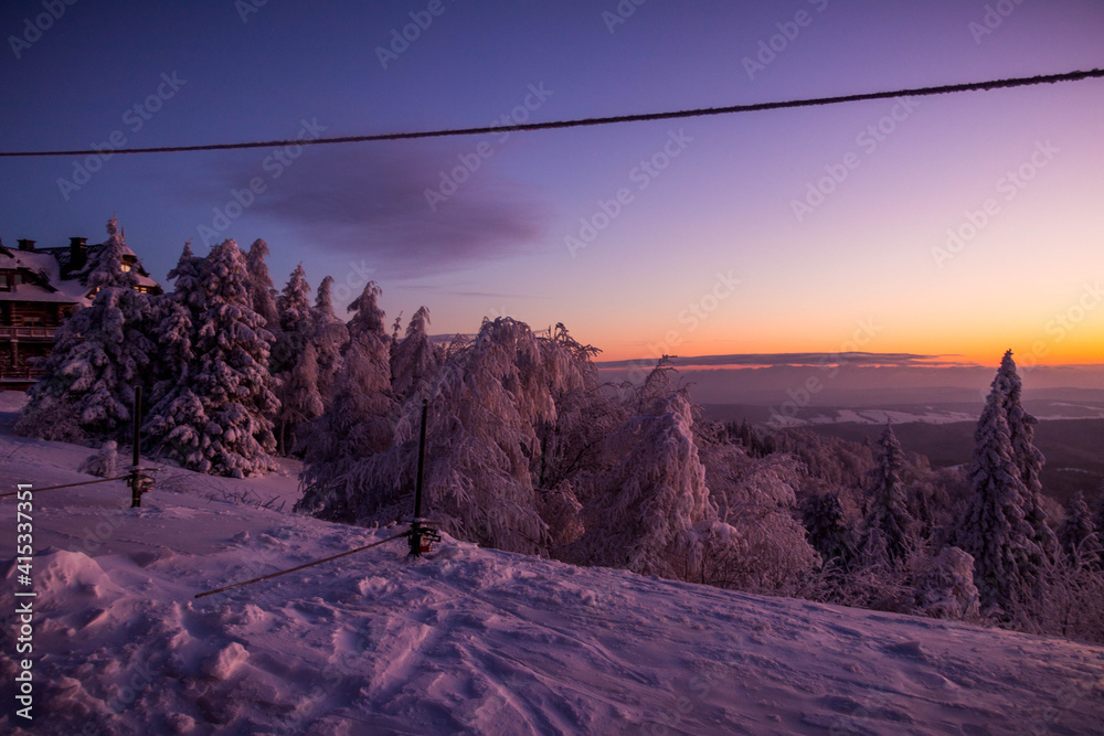 Obraz premium sunrise on a ski slope in the snowy mountains