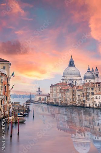 Stunning view of the Venice skyline with the Grand Canal and Basilica Santa Maria Della Salute in the distance during a dramatic sunrise. Picture taken from Ponte Dell’ Accademia, Venice, Italy. © Travel Wild