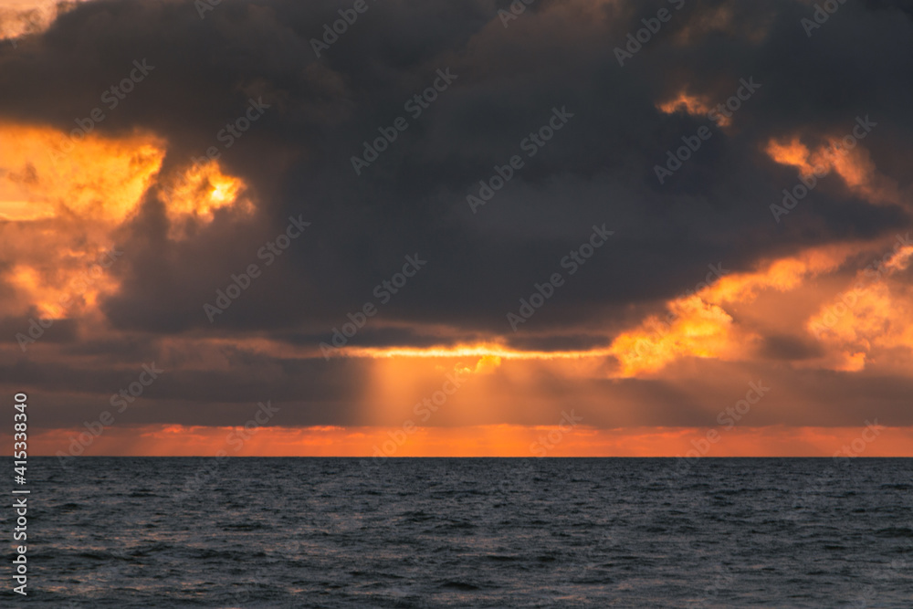Sunset on the ocean with sun rays, French coast line. 
