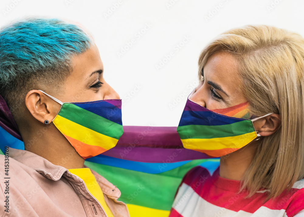 Happy gay couple wearing face mask celebrating gay pride event during corona  virus pandemic - Homosexual love and LGBT concept Stock Photo | Adobe Stock