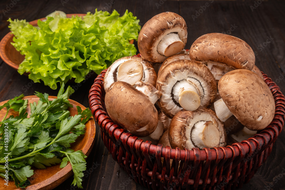 mushrooms in a basket with lettuce and herbs on a dark wooden background mushrooms in a basket with lettuce and herbs on a dark wooden background