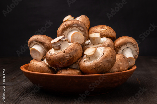 mushrooms in a clay bowl on a dark wooden table
