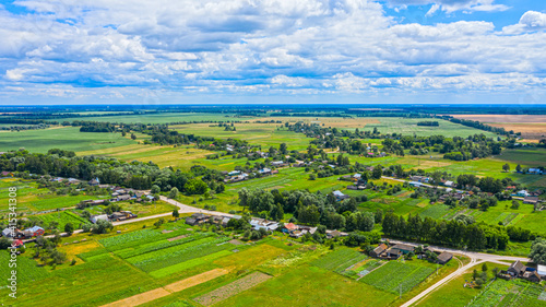 Aerial view over beautiful suburb in wide valley, in the summer. Top view to the small village with a beautiful green landscape.