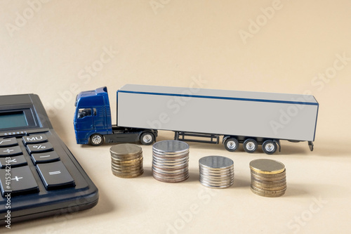 Принти на полотні Calculator, mock-up of tractor-trailer, coins placed on light background