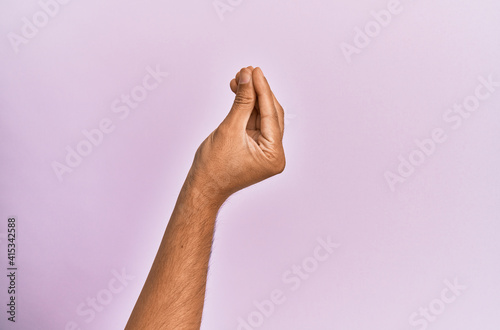 Arm and hand of caucasian young man over pink isolated background doing italian gesture with fingers together, communication gesture movement