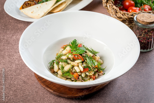 Bean salad in a white plate filmed for the menu