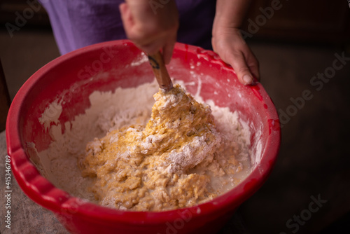 mixing flour with egg and milk by the housewife. preparing ingredients for traditional homemade cakes