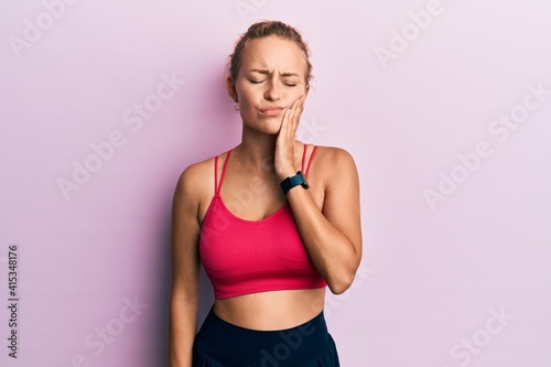Beautiful caucasian woman wearing sportswear touching mouth with hand with painful expression because of toothache or dental illness on teeth. dentist © Krakenimages.com