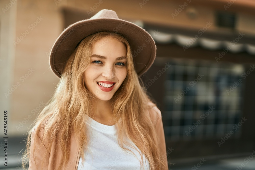 Young blonde girl smiling happy standing at the city.