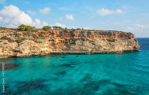 Clear blue green sea water, rocky cliffs around - nice sunny day at Ansa de s'Estri, Mallorca