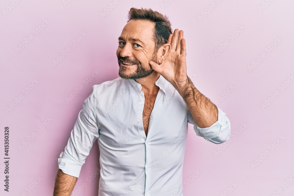 Middle age man wearing casual clothes smiling with hand over ear listening and hearing to rumor or gossip. deafness concept.