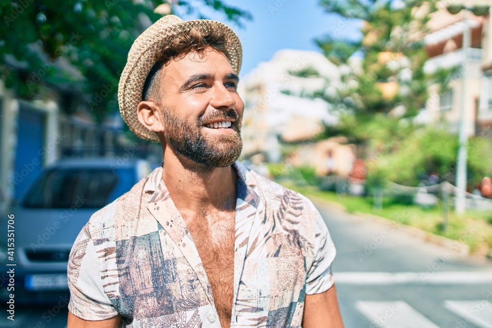 Obraz premium Young hispanic man on vacation smiling happy walking at street of city