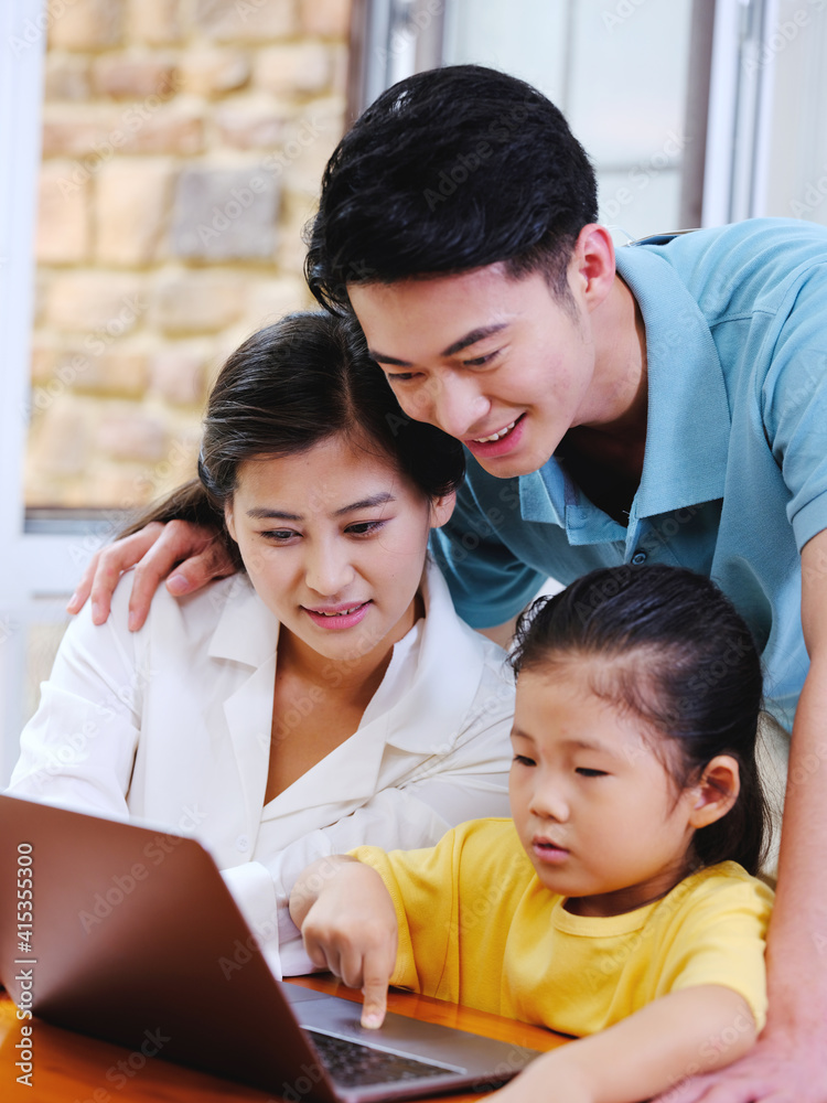 Happy family of three using laptop