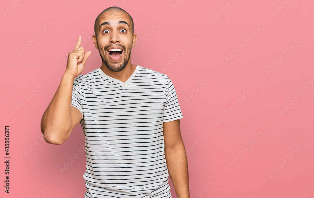 Fototapeta premium Hispanic adult man wearing casual clothes pointing finger up with successful idea. exited and happy. number one.