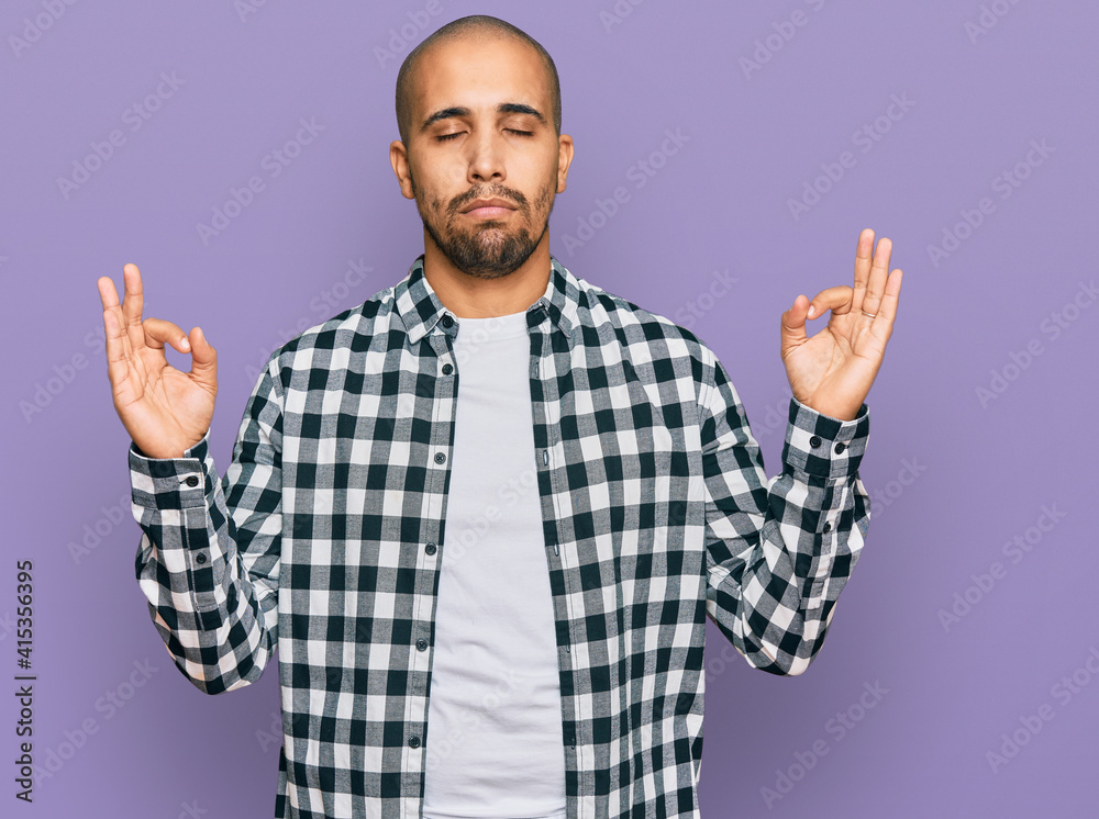 Naklejka premium Hispanic adult man wearing casual clothes relax and smiling with eyes closed doing meditation gesture with fingers. yoga concept.
