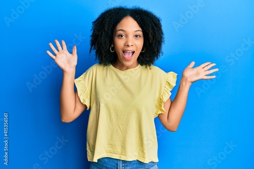 Young african american girl wearing casual clothes celebrating crazy and amazed for success with arms raised and open eyes screaming excited. winner concept