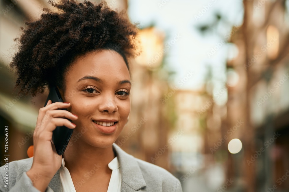 Young african american businesswoman smiling happy talking on the smartphone at the city. Young african american businesswoman smiling happy talking on the smartphone at the city.