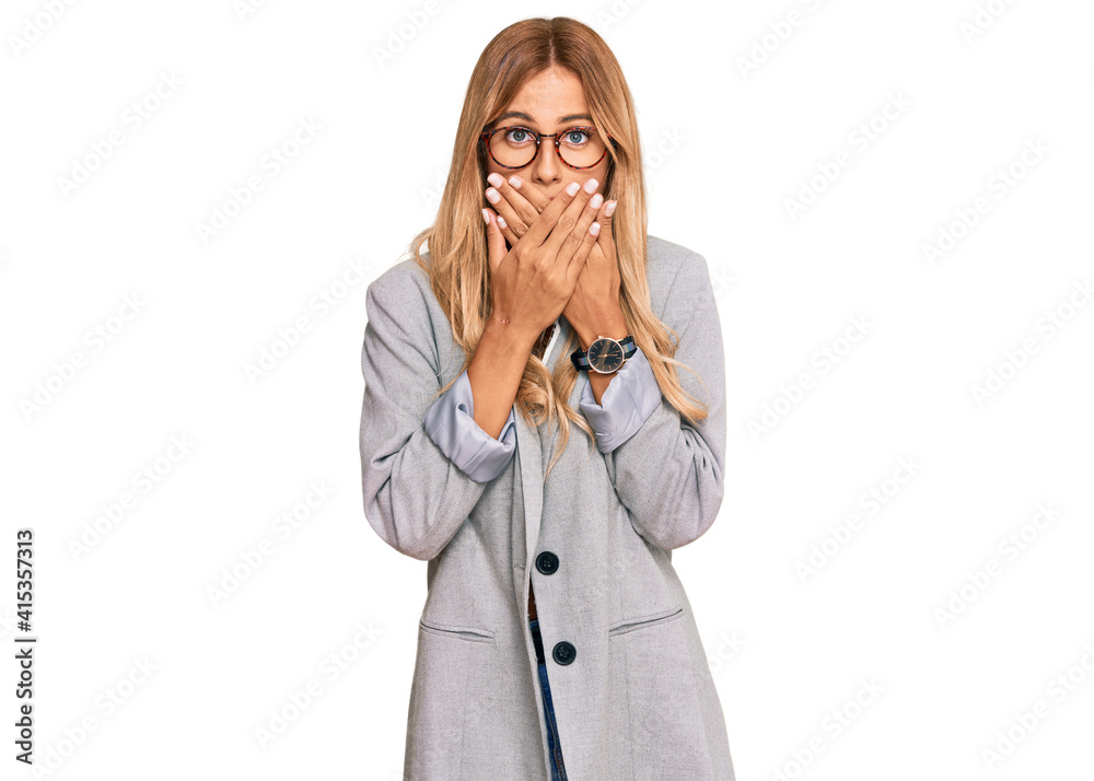 Beautiful blonde young woman wearing business clothes shocked covering mouth with hands for mistake. secret concept. Beautiful blonde young woman wearing business clothes shocked covering mouth with hands for mistake. secret concept.