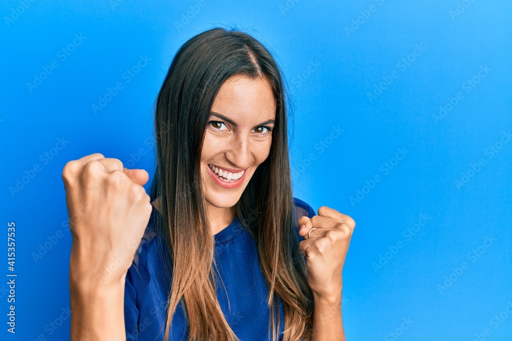 Young beautiful woman wearing casual clothes screaming proud, celebrating victory and success very excited with raised arms Young beautiful woman wearing casual clothes screaming proud, celebrating victory and success very excited with raised arms