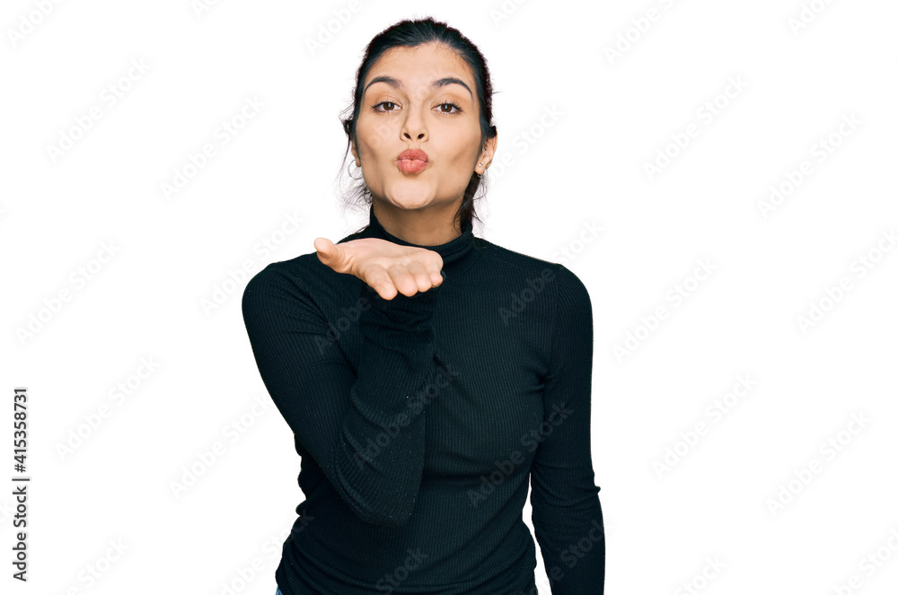 Young hispanic woman wearing casual clothes looking at the camera blowing a kiss with hand on air being lovely and sexy. love expression. Young hispanic woman wearing casual clothes looking at the camera blowing a kiss with hand on air being lovely and sexy. love expression.