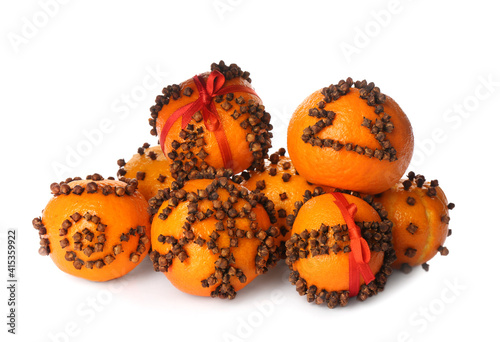 Pile of pomander balls made of fresh tangerines with cloves on white background photo