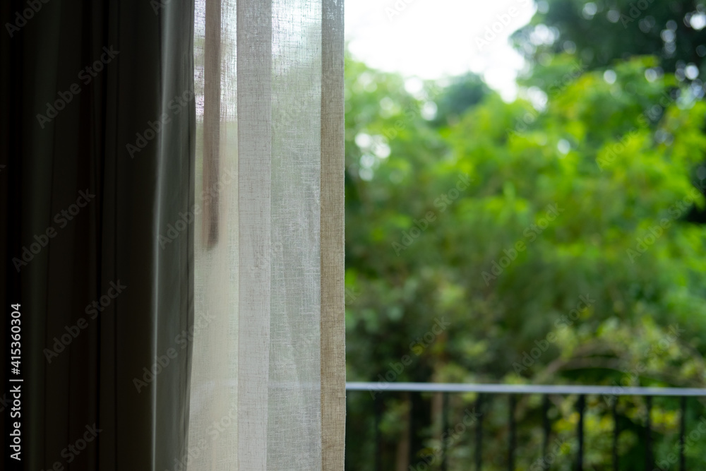 Naklejka premium Transparent white curtain with garden view background in morning