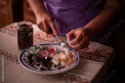 housewife slicing Turkish delicacies into small cubes on a plate