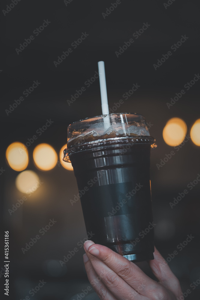 Take away plastic cup of iced black coffee Americano on hand Take away plastic cup of iced black coffee Americano on hand
