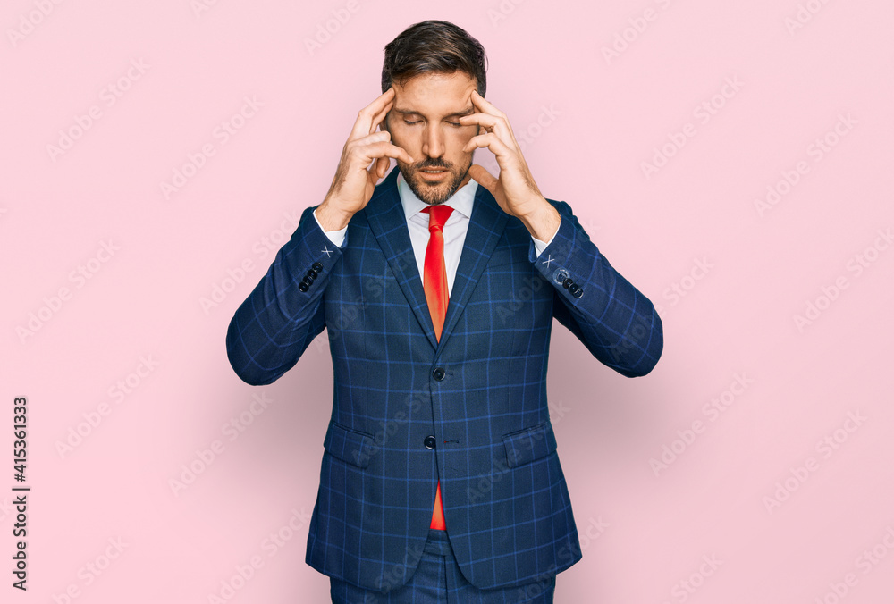 Handsome man with beard wearing business suit and tie with hand on head for pain in head because stress. suffering migraine. Handsome man with beard wearing business suit and tie with hand on head for pain in head because stress. suffering migraine.