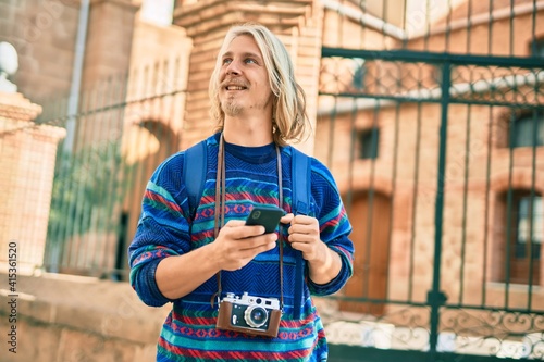 Young scandinavian tourist man smiling happy using smartphone at the city. photo