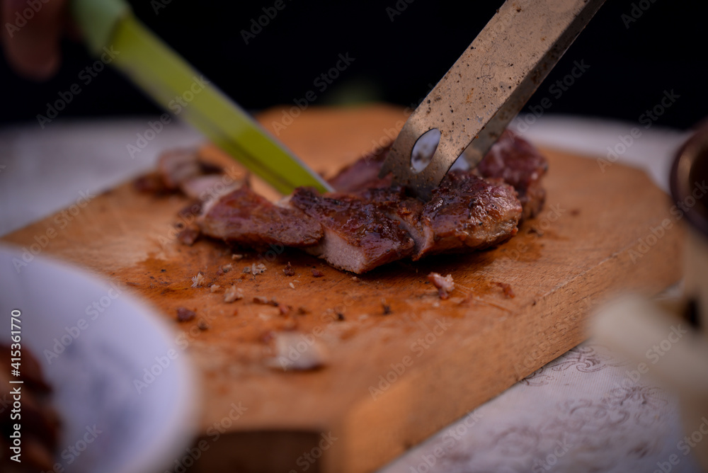 Slicing pork barbecue recipe on a hand made vintage chopping board Slicing pork barbecue recipe on a hand made vintage chopping board