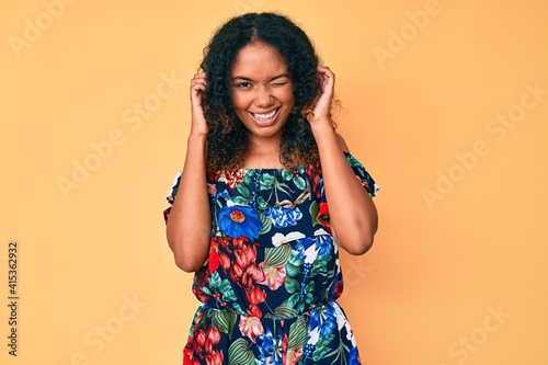 Young african american woman wearing casual clothes covering ears with fingers with annoyed expression for the noise of loud music. deaf concept.