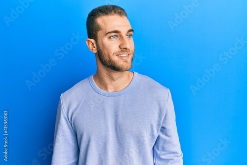 Young caucasian man wearing casual clothes looking to side, relax profile pose with natural face and confident smile.