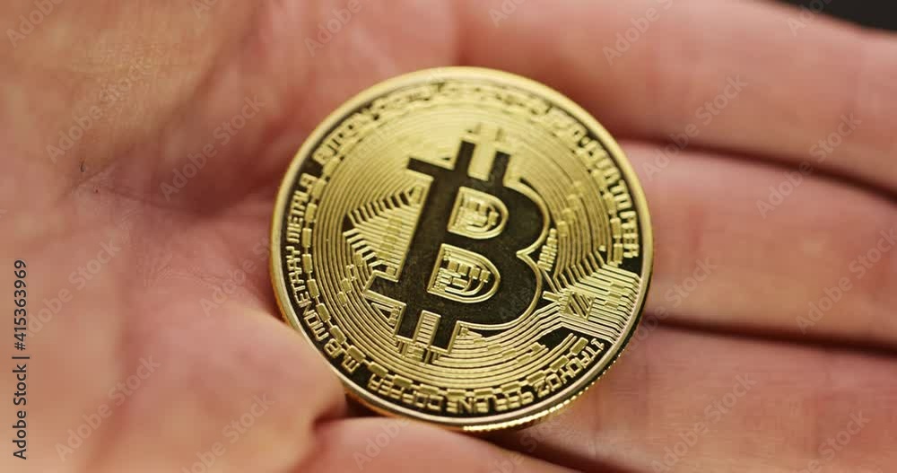 Inspecting Physical bitcoin held in hands closeup Inspecting Physical bitcoin held in hands closeup