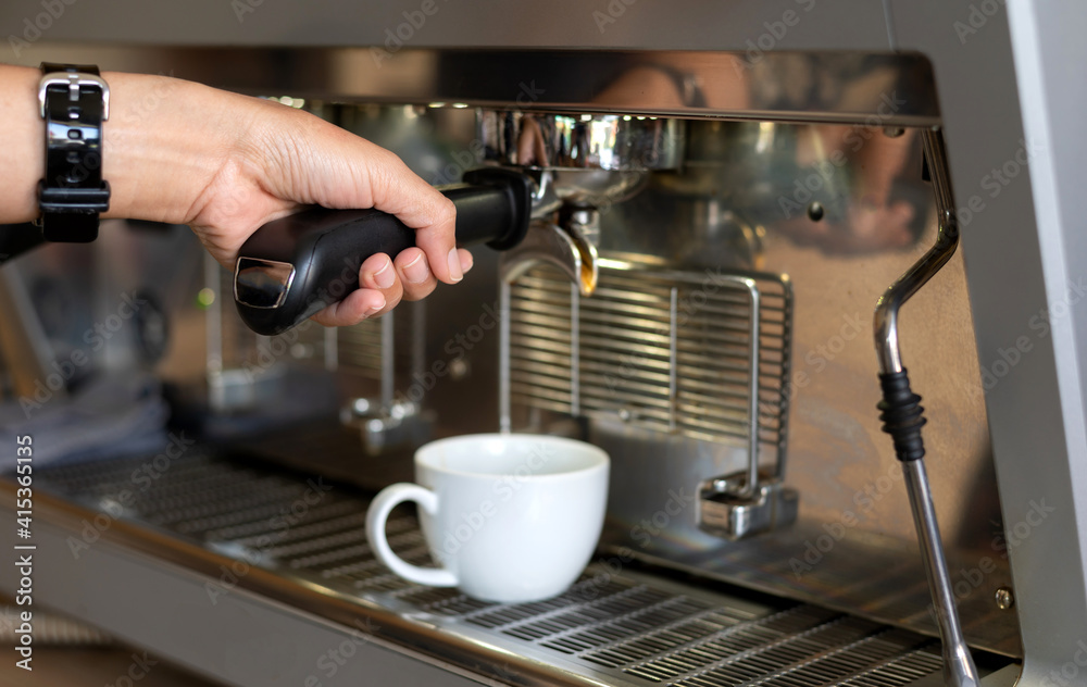 Close up hand barista holding Espresso coffee machine piston  on blurred background.Photo select focus.