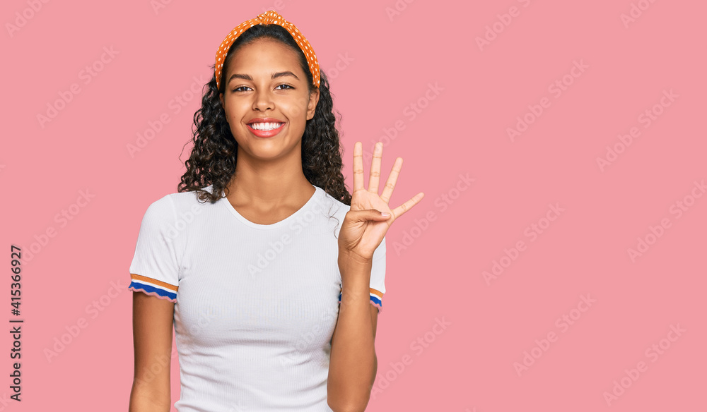 Young african american girl wearing casual clothes showing and pointing up with fingers number four while smiling confident and happy.