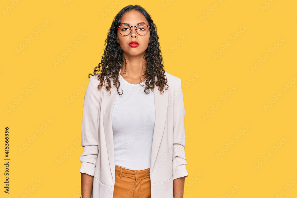 Young african american girl wearing business clothes relaxed with serious expression on face. simple and natural looking at the camera. Young african american girl wearing business clothes relaxed with serious expression on face. simple and natural looking at the camera.