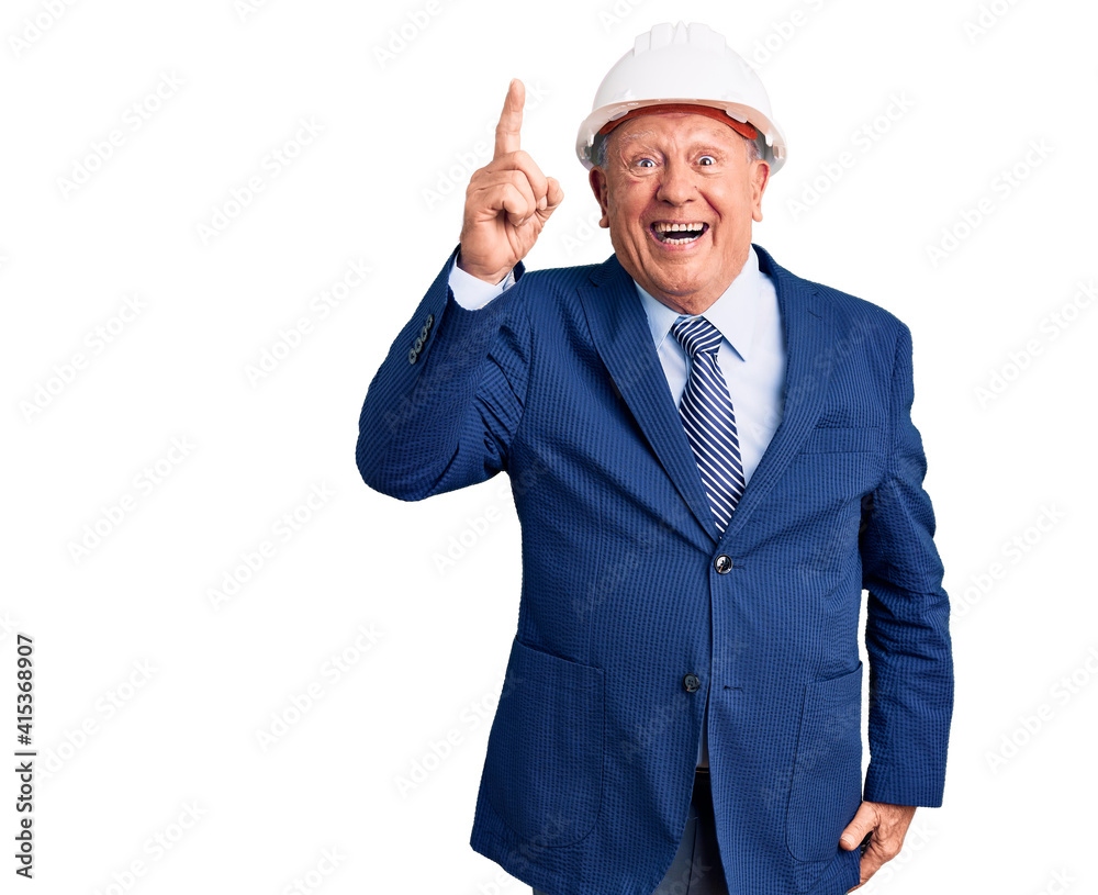 Senior handsome grey-haired man wearing suit and architect hardhat pointing finger up with successful idea. exited and happy. number one. Senior handsome grey-haired man wearing suit and architect hardhat pointing finger up with successful idea. exited and happy. number one.