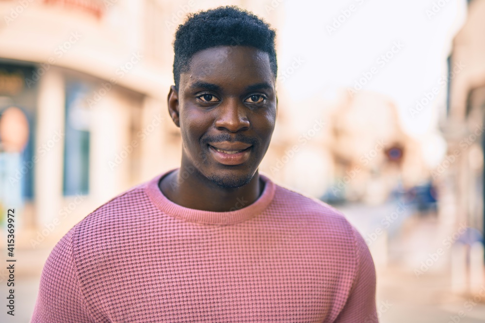 Obraz premium Young african american man smiling happy standing at the city.