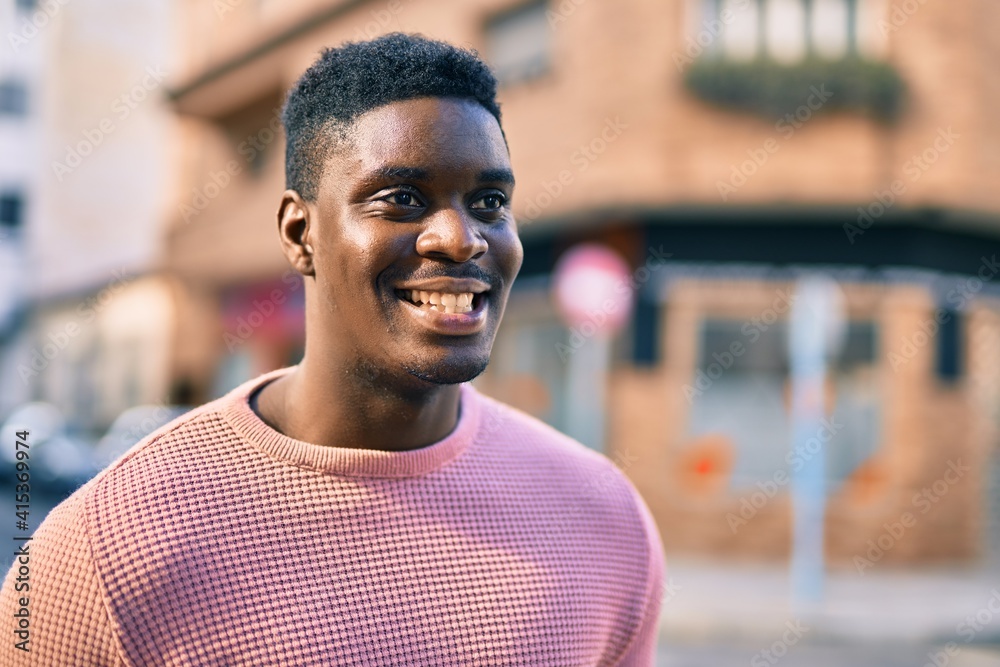 Young african american man smiling happy standing at the city. Young african american man smiling happy standing at the city.