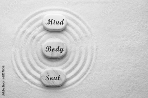 Photography Stones with words Mind, Body, Soul on sand, flat lay