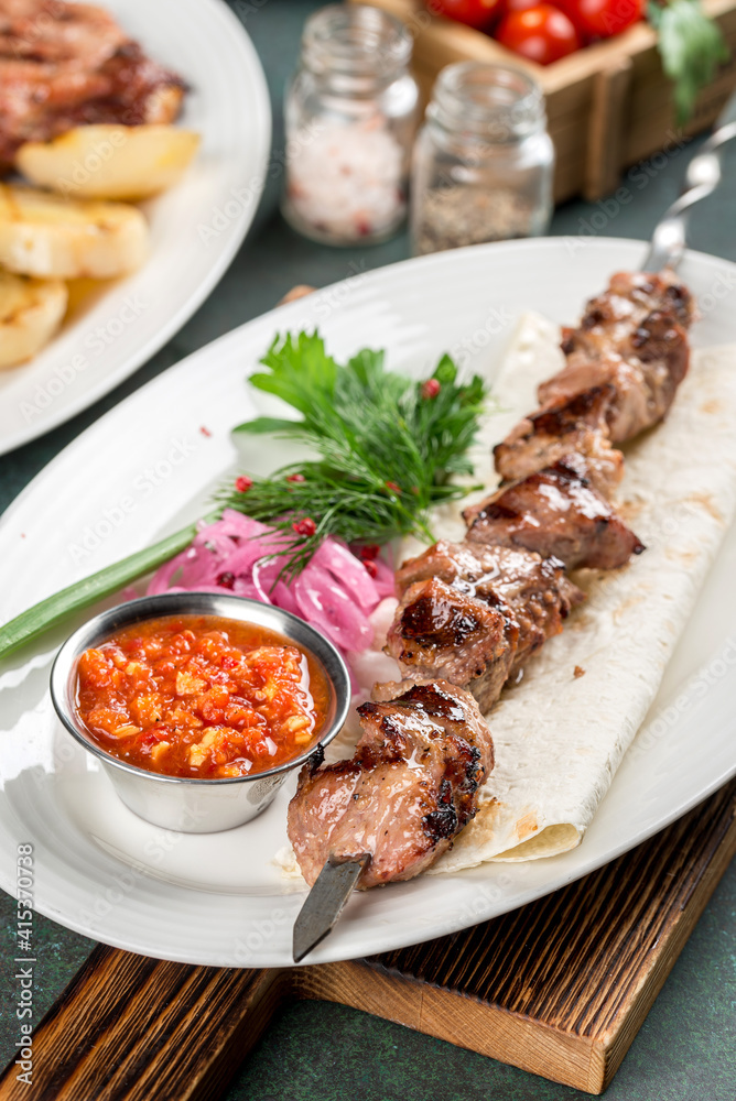 Pork shashlik with sauce and flatbread close-up Pork shashlik with sauce and flatbread close-up
