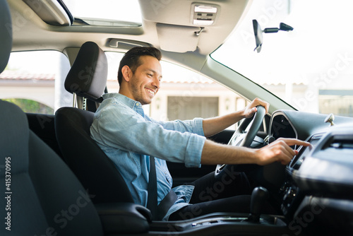 Canvas Print Attractive male driver using the GPS navigation map on the car