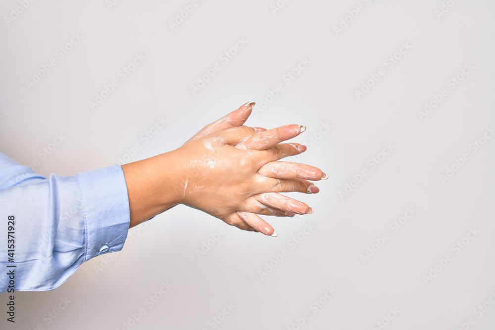 Young caucasian woman cleaning hands using alcohol liquid over isolated white background